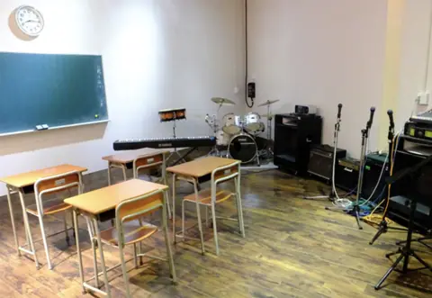 ライブハウス AVANTI（練習スタジオ）（ドラムとマイクスタンド、机と椅子のある部屋）