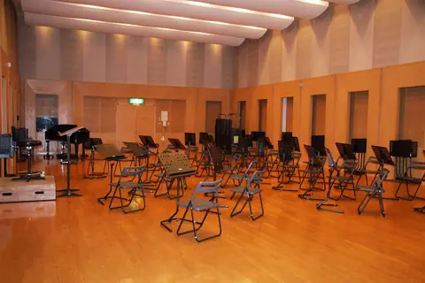 福井県立音楽堂 ハーモニーホールふくい 練習室：譜面台と椅子が並ぶ広い練習室