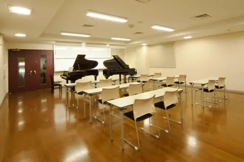 京都堀川音楽高等学校 レッスン室：机とグランドピアノのあるレッスン室